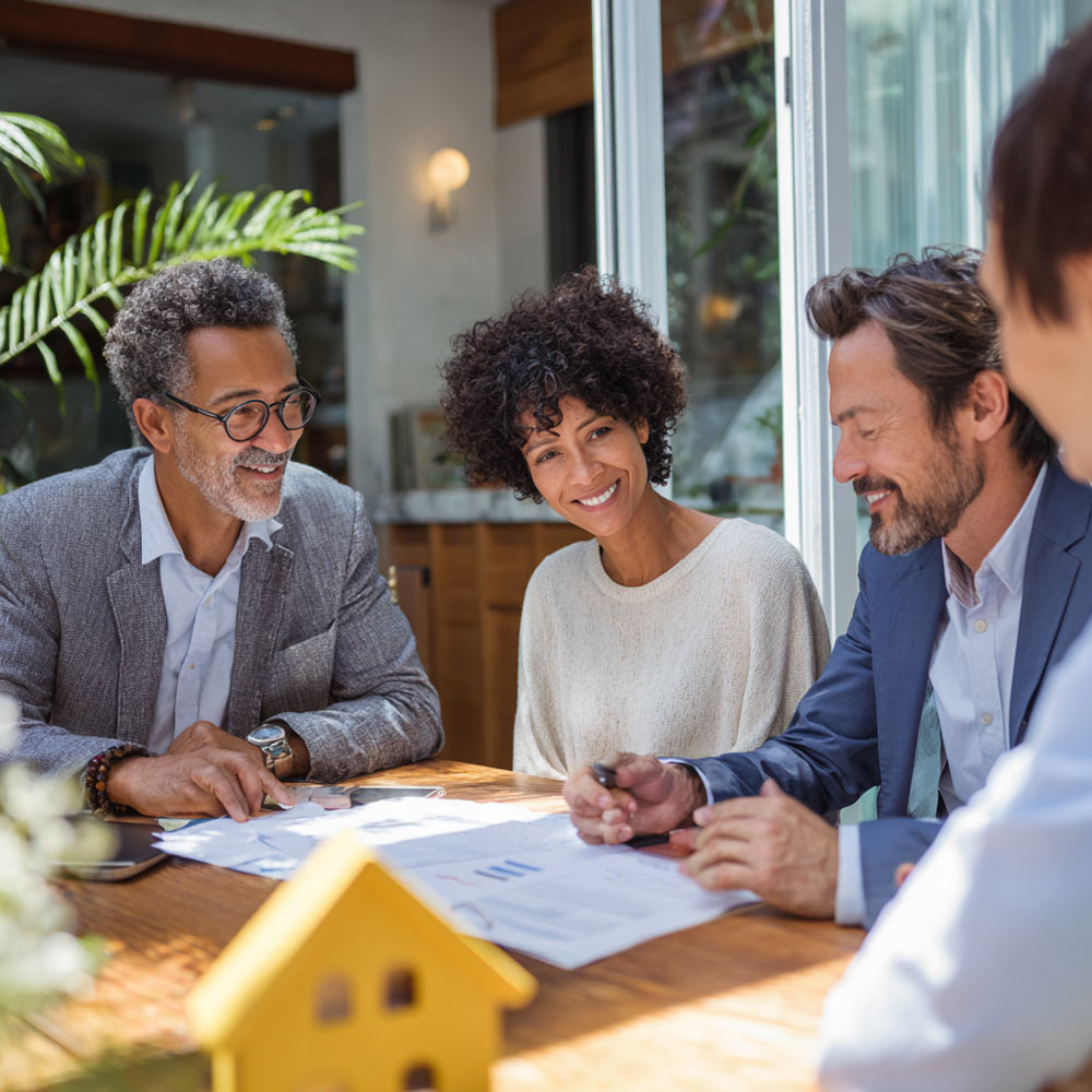 California real estate agent reviewing disclosures and consumer protection documents with clients during a home purchase consultation.